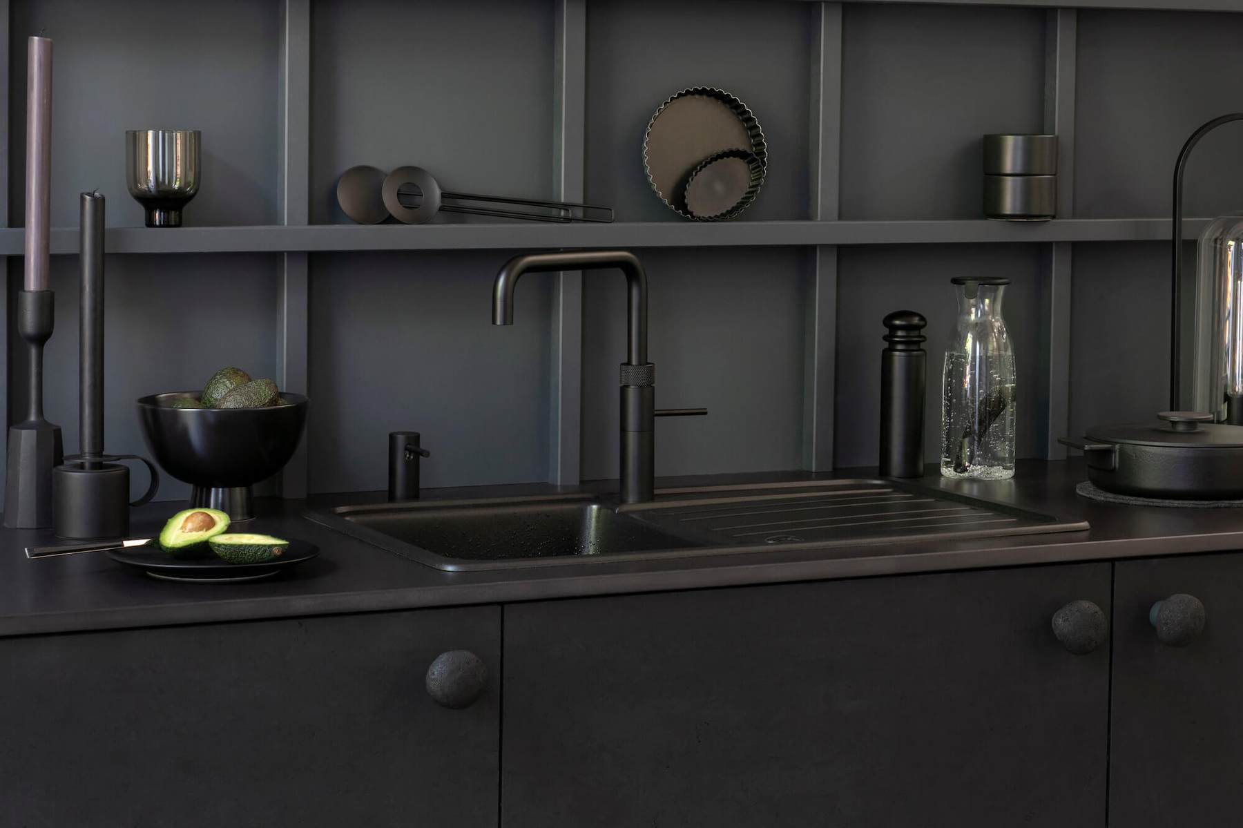 Quooker Kochend-Wasserhahn: Quooker Armatur in Schwarz an einer dunklen Spüle vor Regalwand