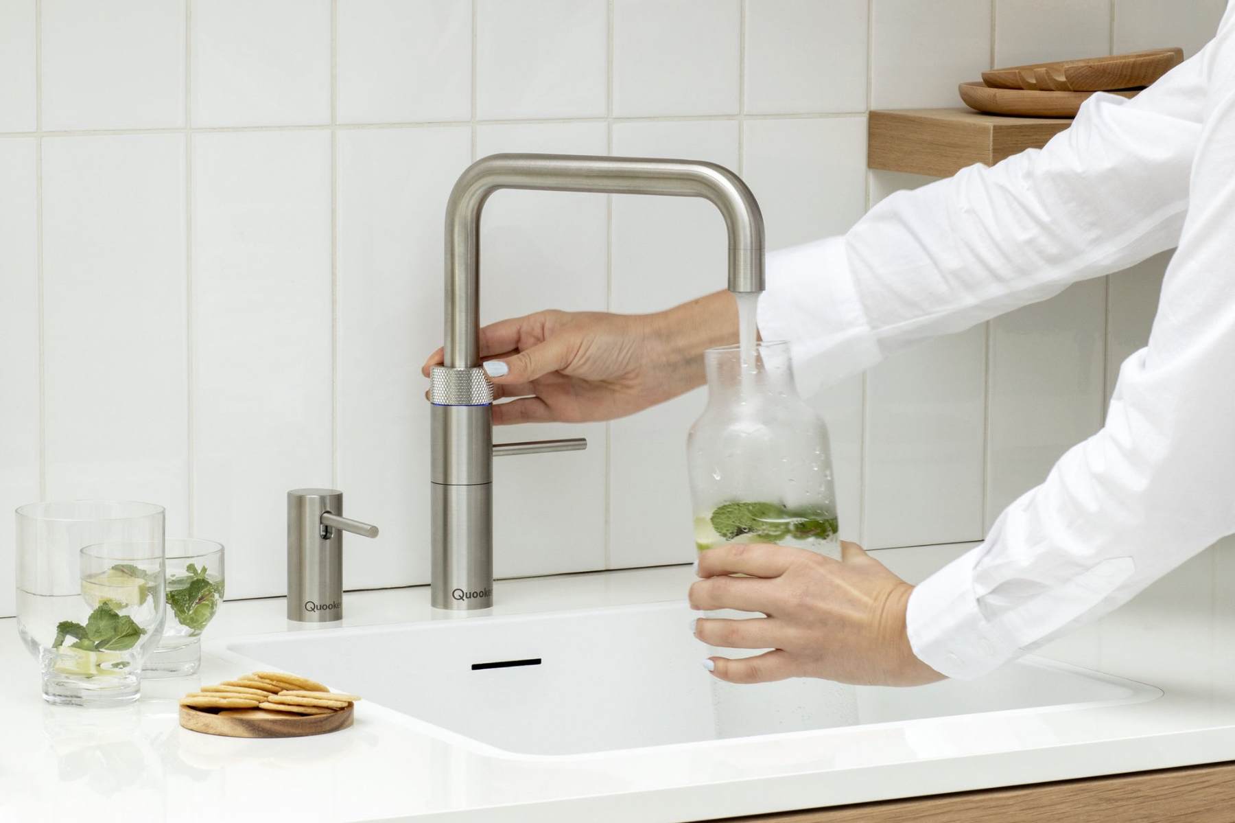 Quooker Fusion Square in Edelstahl, aus dem Sprudelwasser in eine Flasche läuft